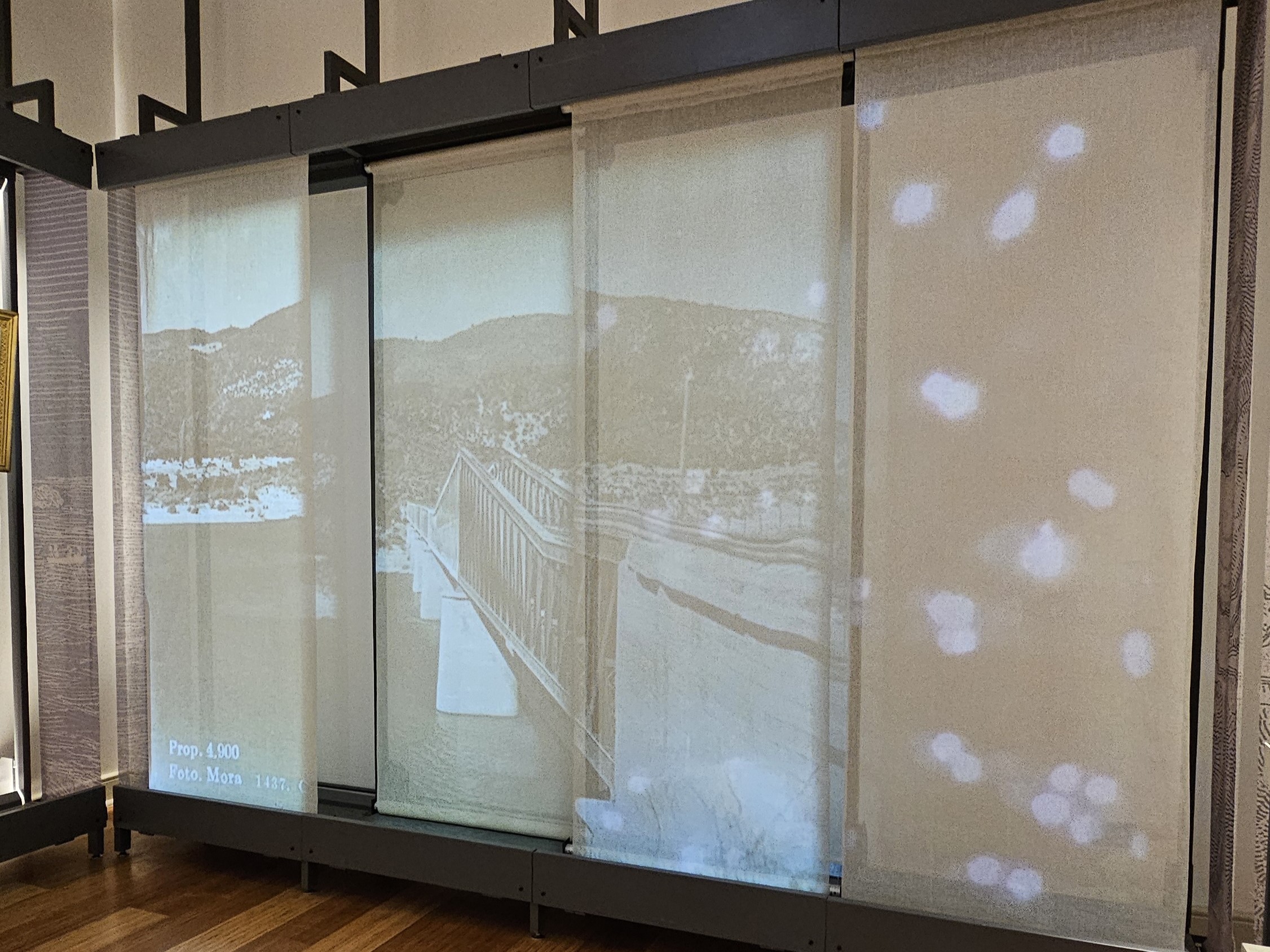 Fotografía de mural con imágenes proyectadas de un puente del sector